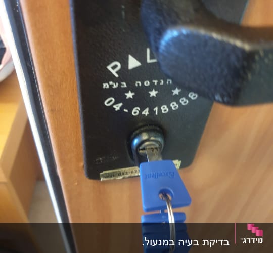 מנעול עם מפתח כחול בדלת עץ